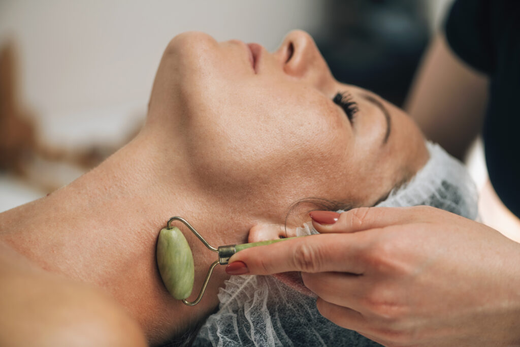 A female relaxing while a face roller is being used on her neck. 