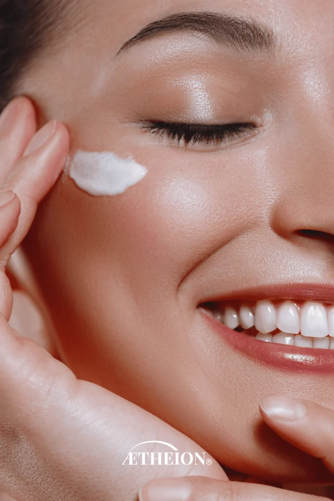 7 Reasons Mineral Skincare Is Changing Skin Health Forever in 2025 Woman smiling while applying mineral-based skincare cream under eye, showcasing healthy radiant skin with AETHEION® formula.